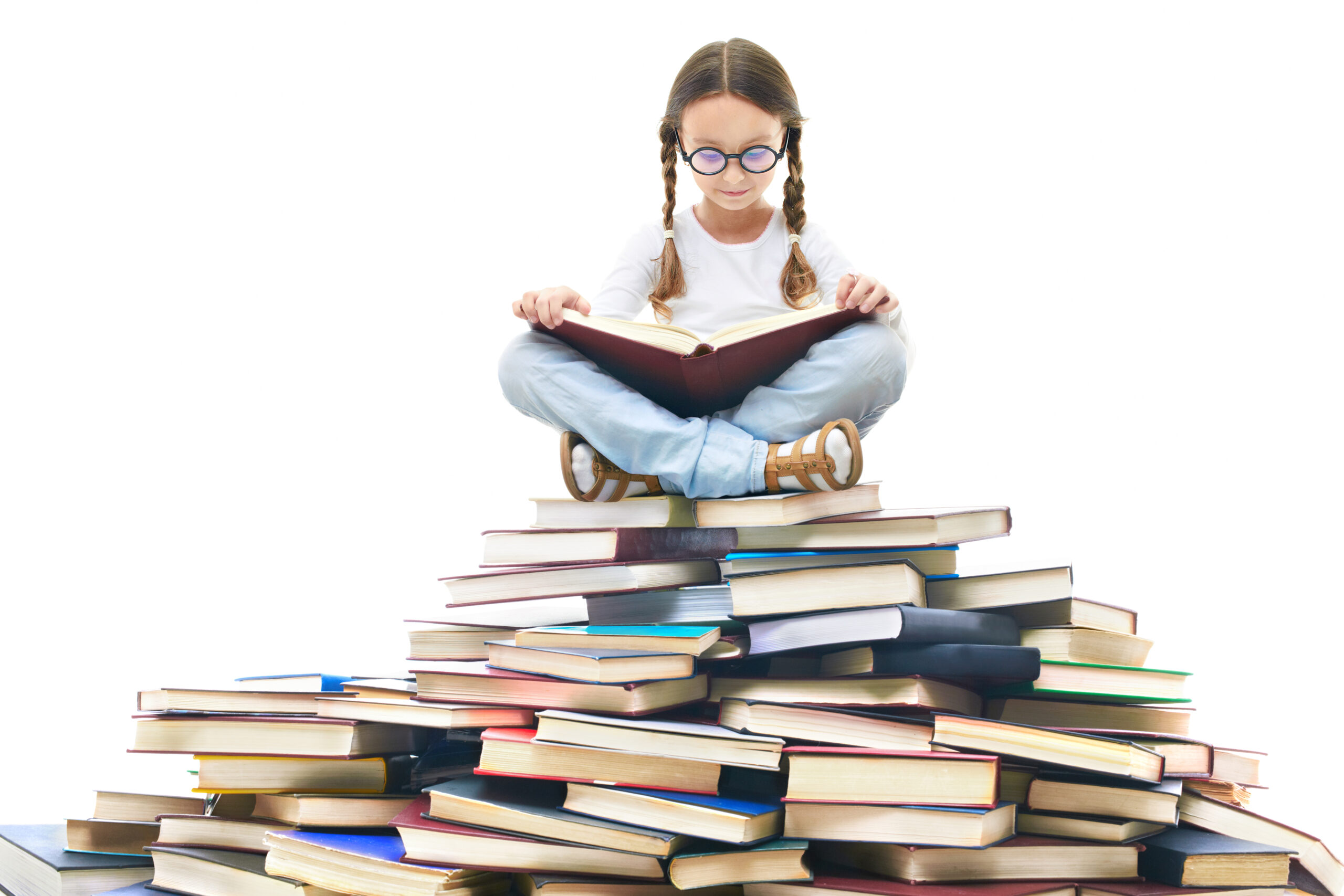 A girl reading atop a pile of books